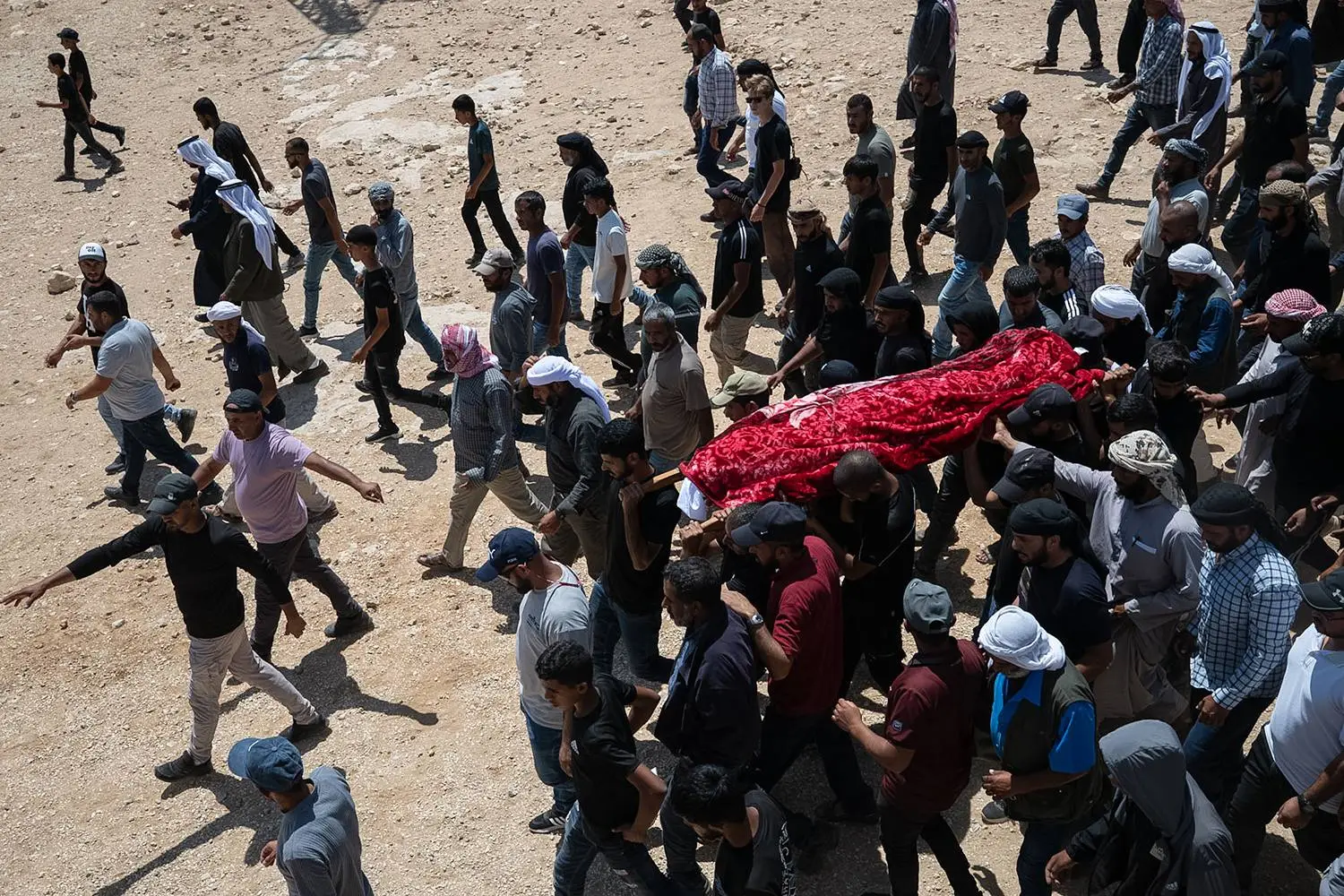 Family and friends of Palestinian activist Awdah Hathaleen carry his body to the cemetery during his funeral in Umm al-Kheir, West Bank, on Aug. 7.