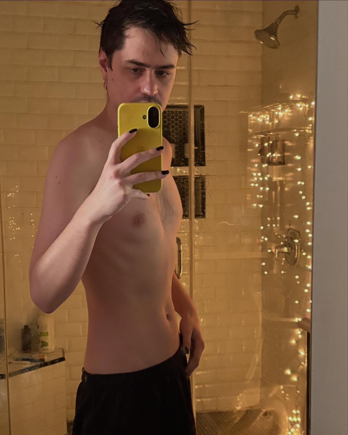 Sean Nicholson shirtless in a bathroom. 