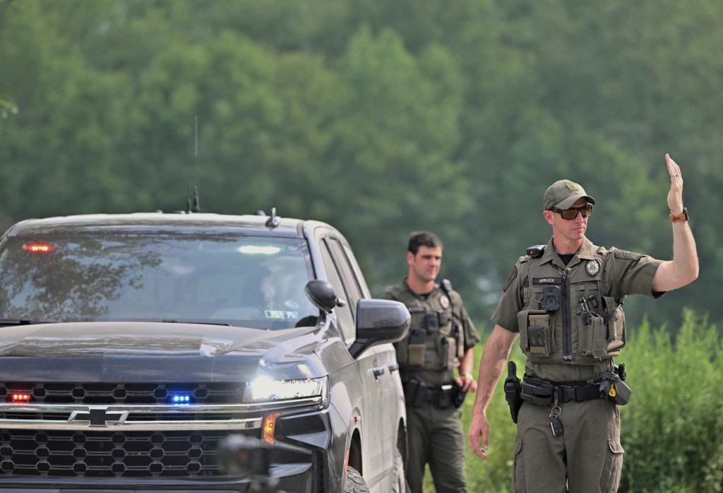 Police officers block the street leading to where two Pennsylvania state troopers were ambushed and shot Thursday, Aug. 7, 2025, near the village of Thompson in Susquehanna County, Pa.