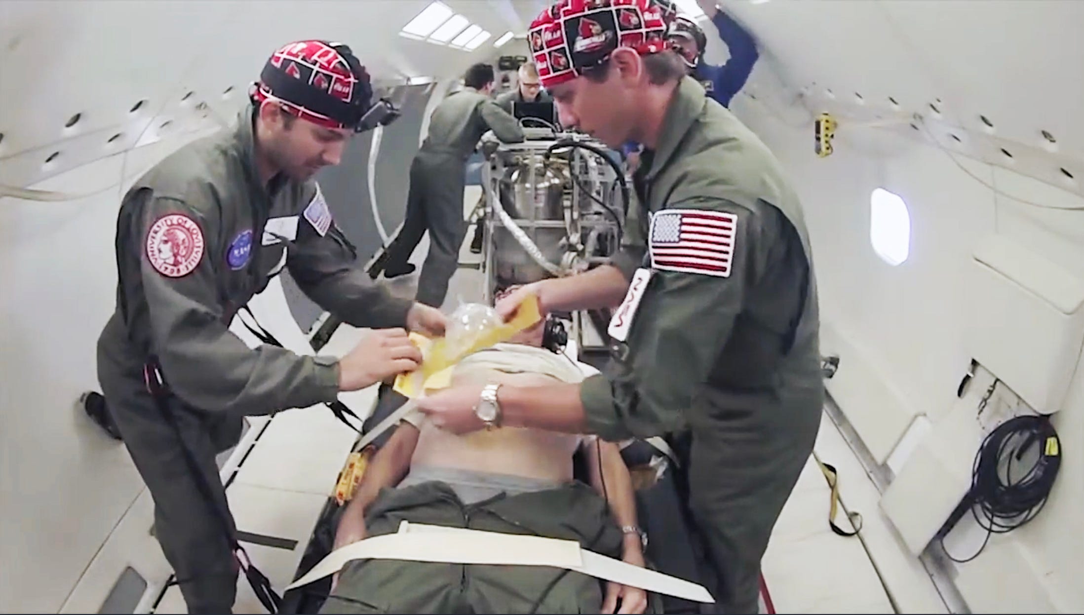 two people attempting to perform surgery in zero-G simulator