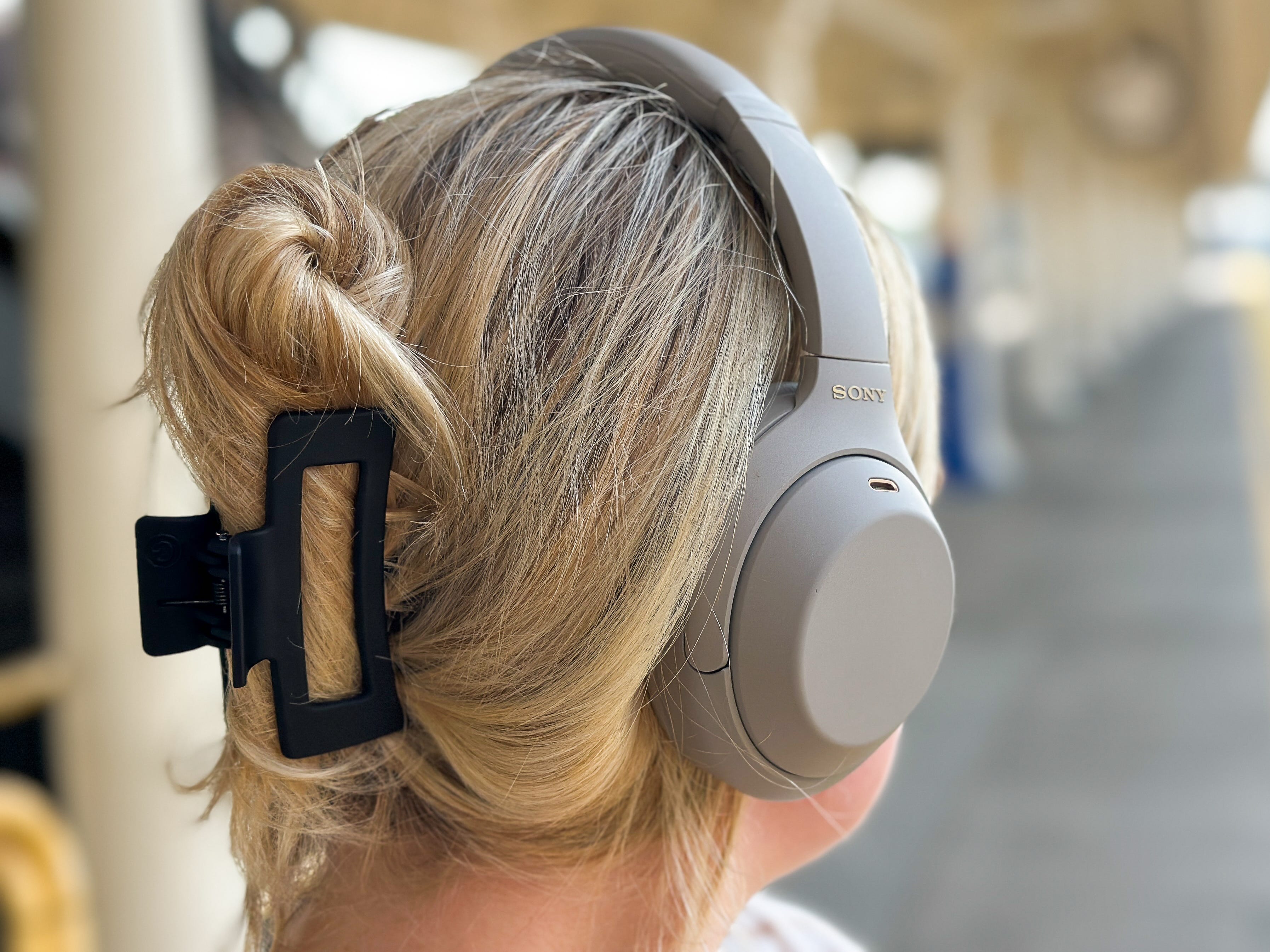 Kylie wearing a pair of beige over-the-ear Sony headphones.