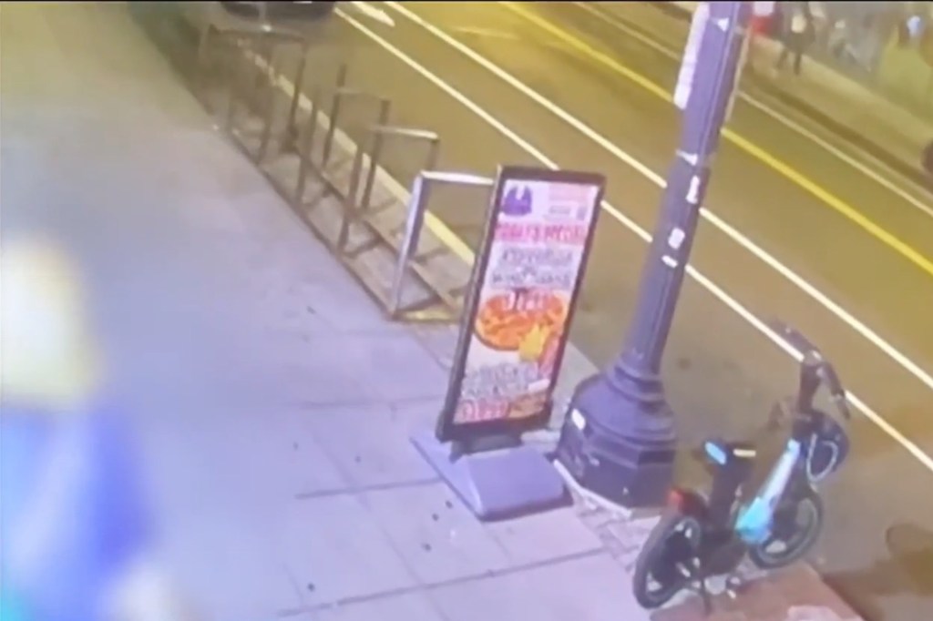 Security camera footage of a street scene showing a parked scooter and a pizza advertisement.