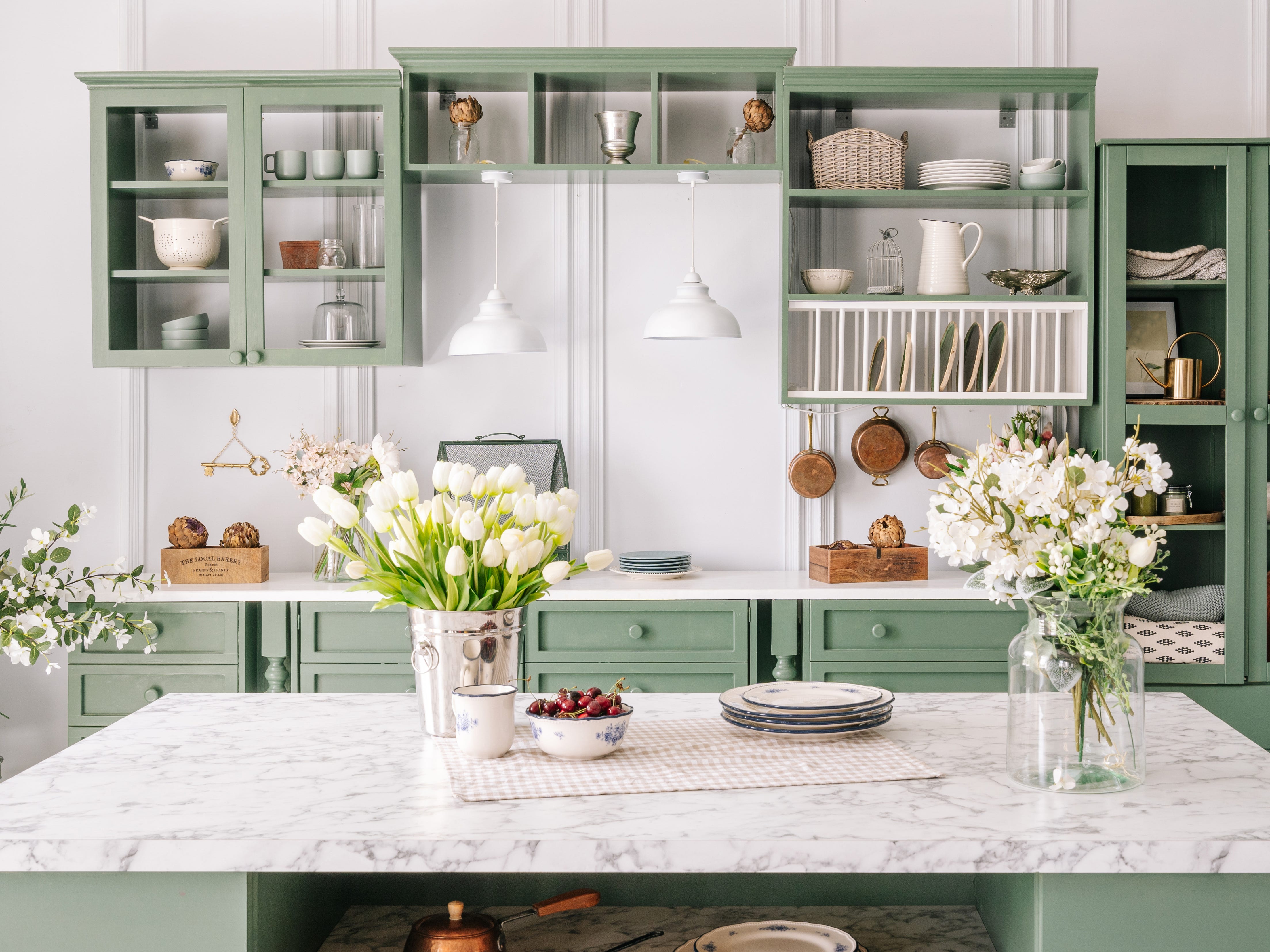 Green cabinets and neutral countertops in kitchen