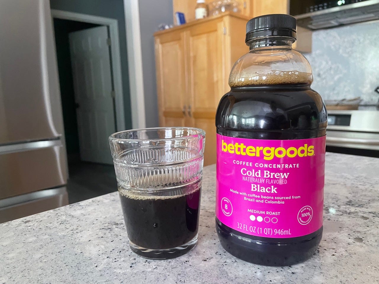 Bettergoods cold brew bottle next to glass of cold brew