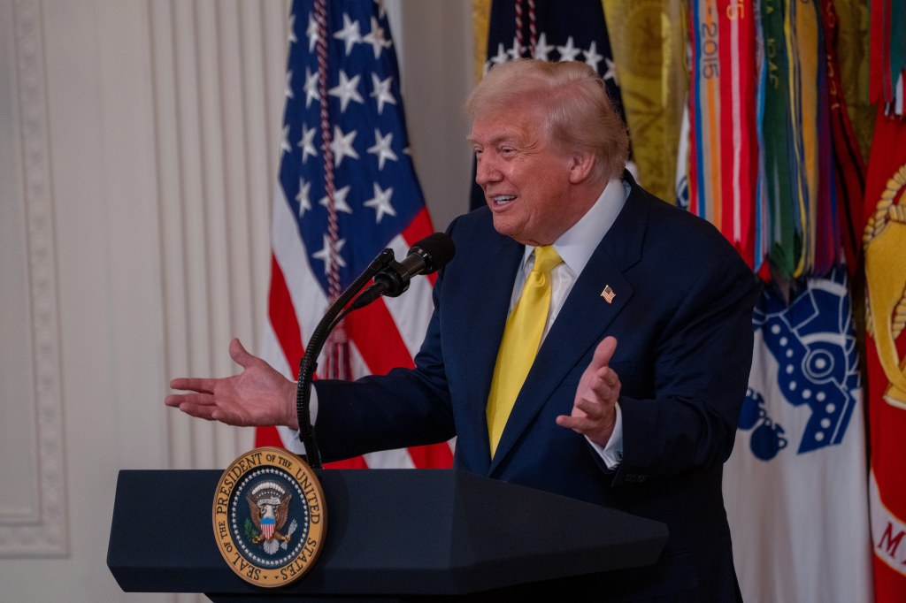 President Trump speaking at a podium during a National Purple Heart Day ceremony.