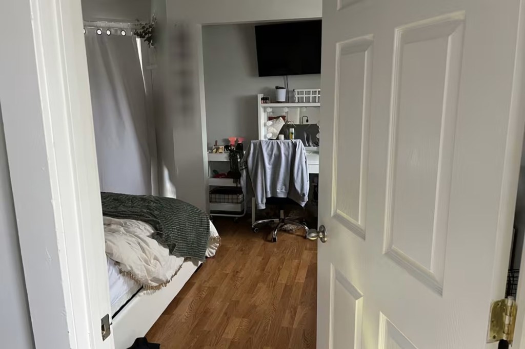 Photo of the interior of a bedroom, showing a bed, desk, and television.