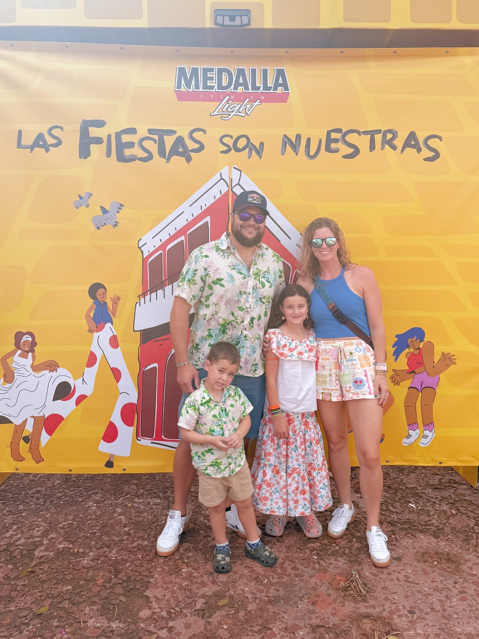 A family of four posing for a picture in front of a sign in Spanish.