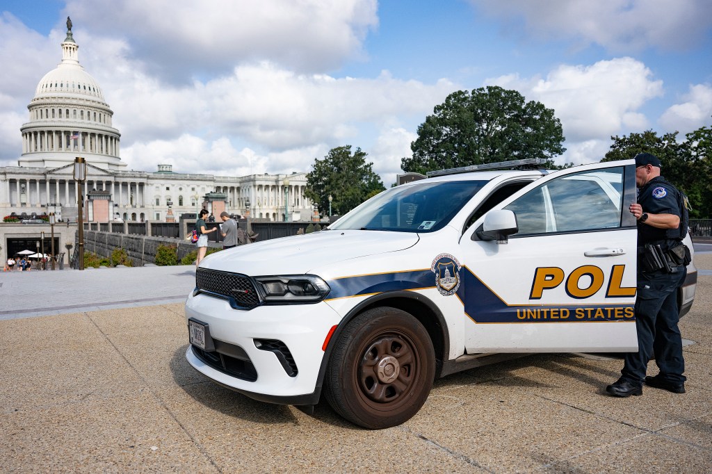 US Capitol Police officer standing by his vehicle near the US Capitol.