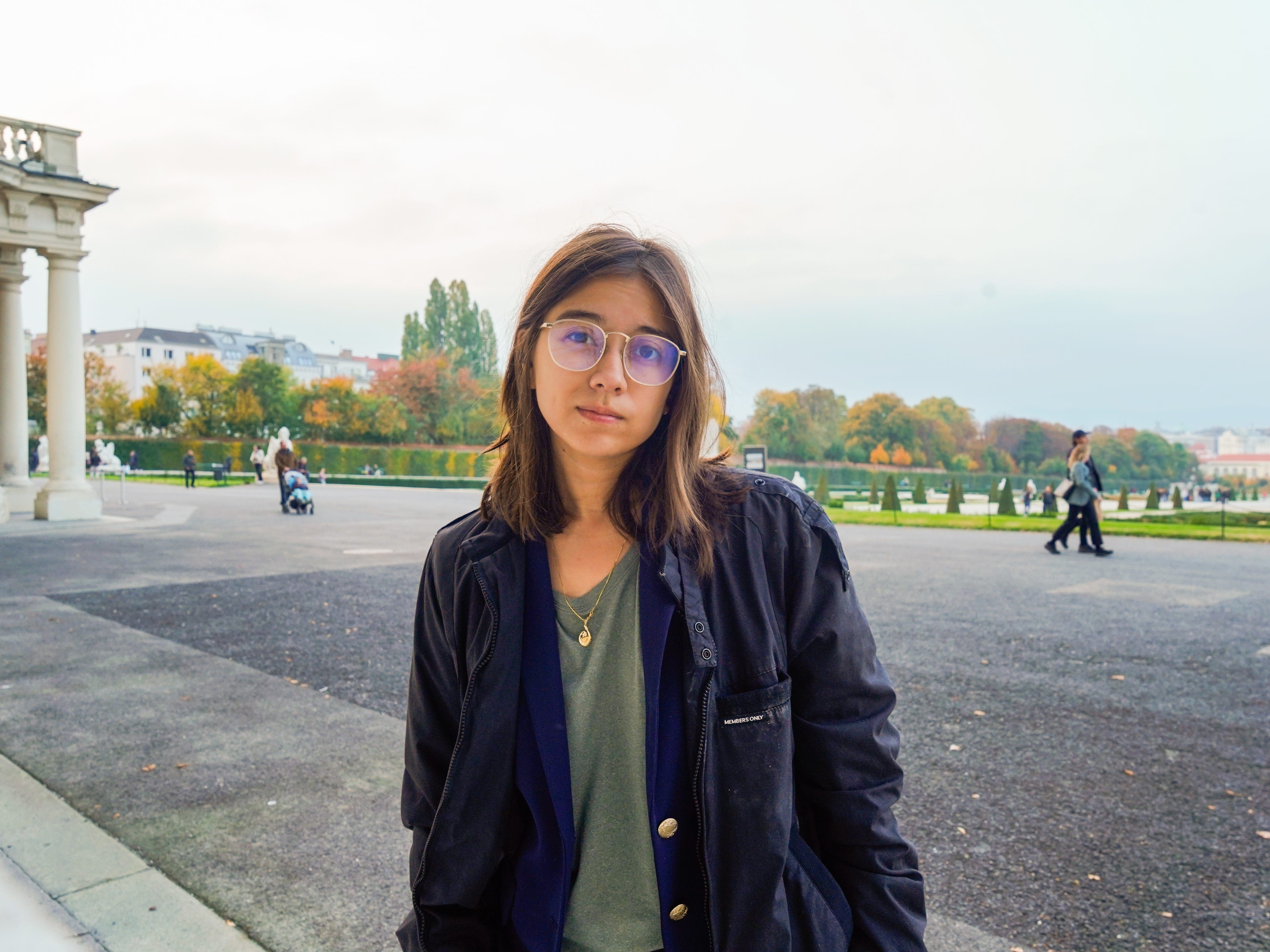 The author stands in front of a garden in Vienna