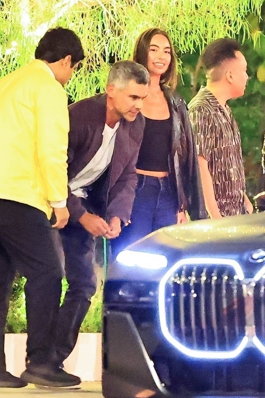 Cash Warren and Hana Sun Doerr step into a BMW. 