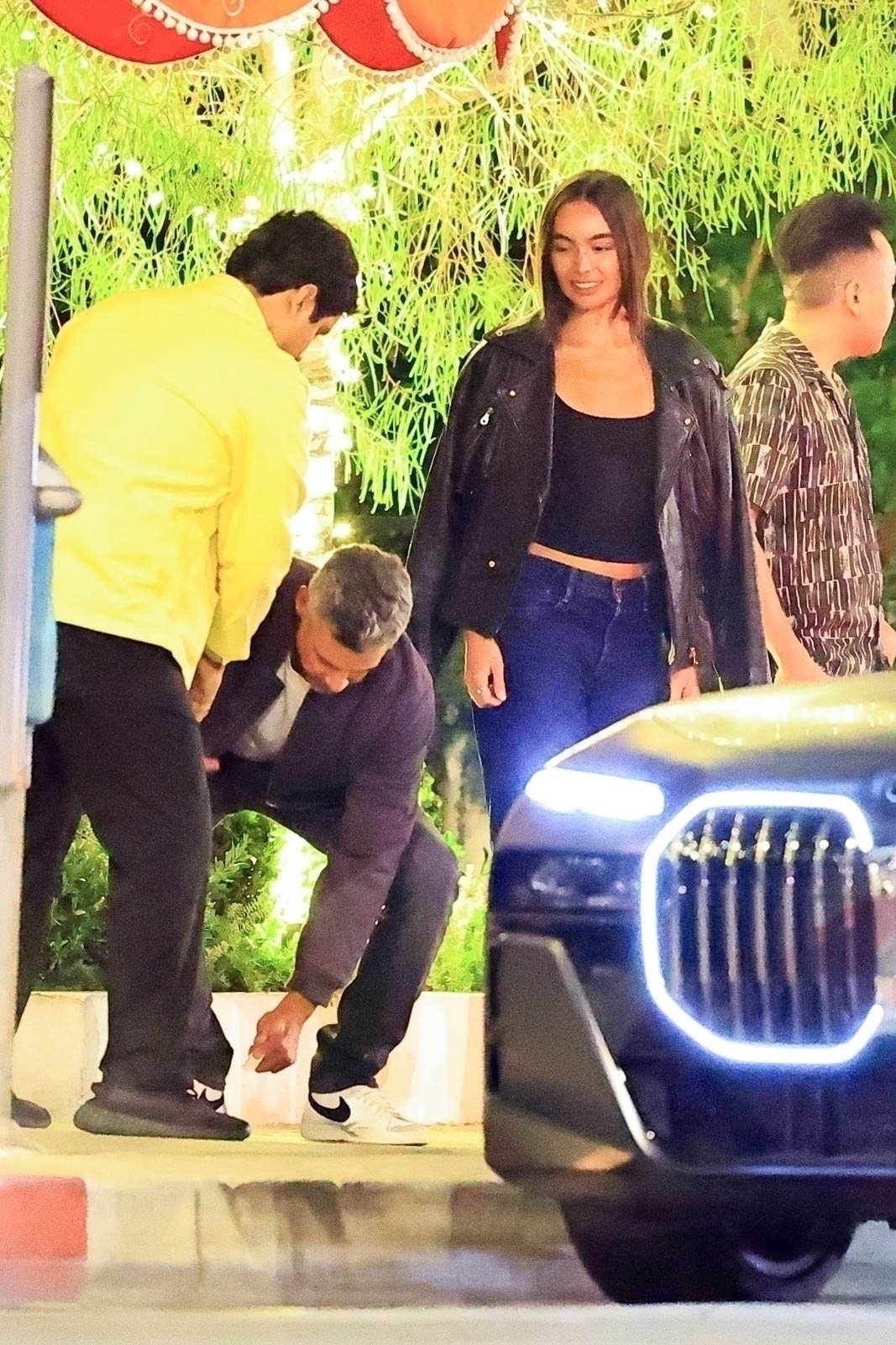 Cash Warren picks something off the ground while Hana Sun Doerr watches. 