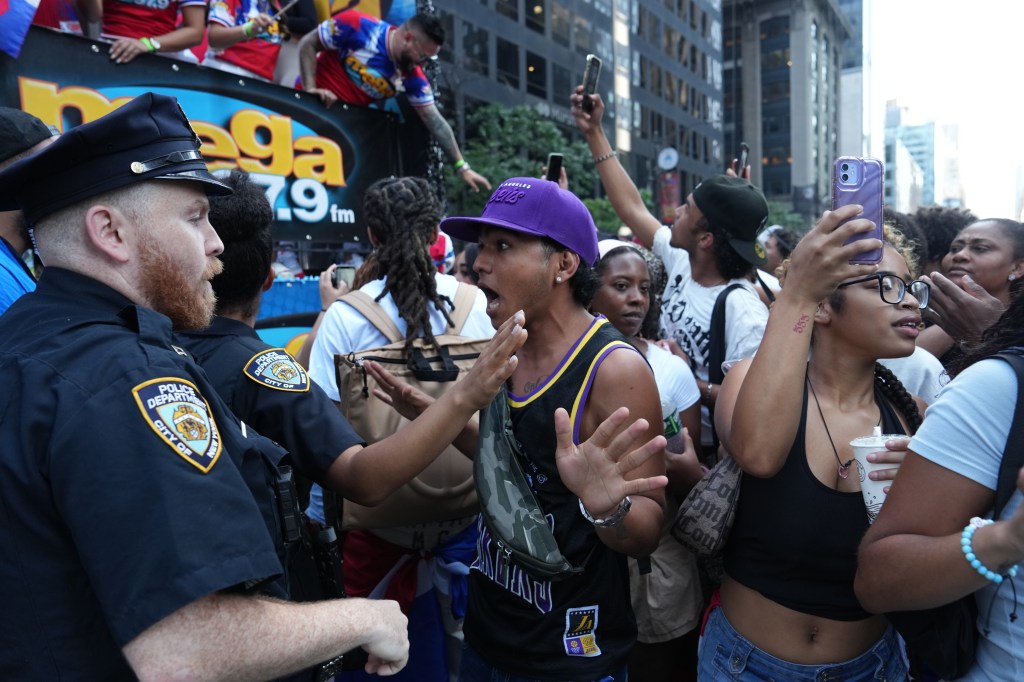 Members of the New York City Police Department perform crowd control as spectators overflowed onto the path of the parade during the National Dominican Day Parade on Sunday, August 11, 2024 in New York, N.Y.  