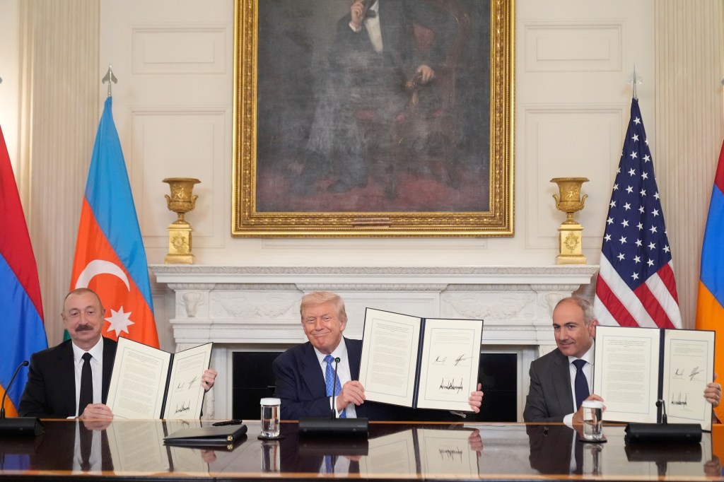 Donald Trump, Nikol Pashinyan, and Ilham Aliyev holding signed documents.