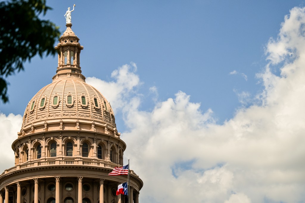 Texas State Capitol dome with US and Texas flags.