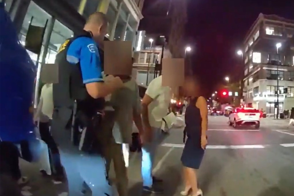 Police officer detaining individuals at night.