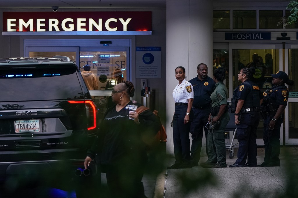 Police officers outside a hospital emergency entrance following an active shooter incident.