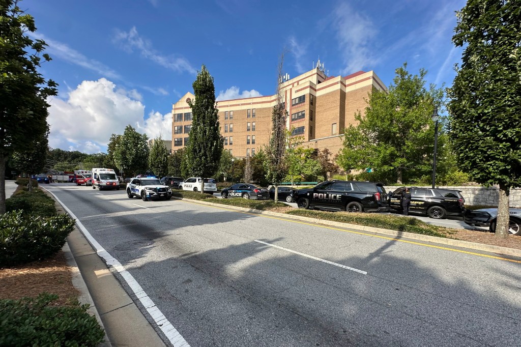 Police cars and an ambulance outside a building following a shooting at Emory University.