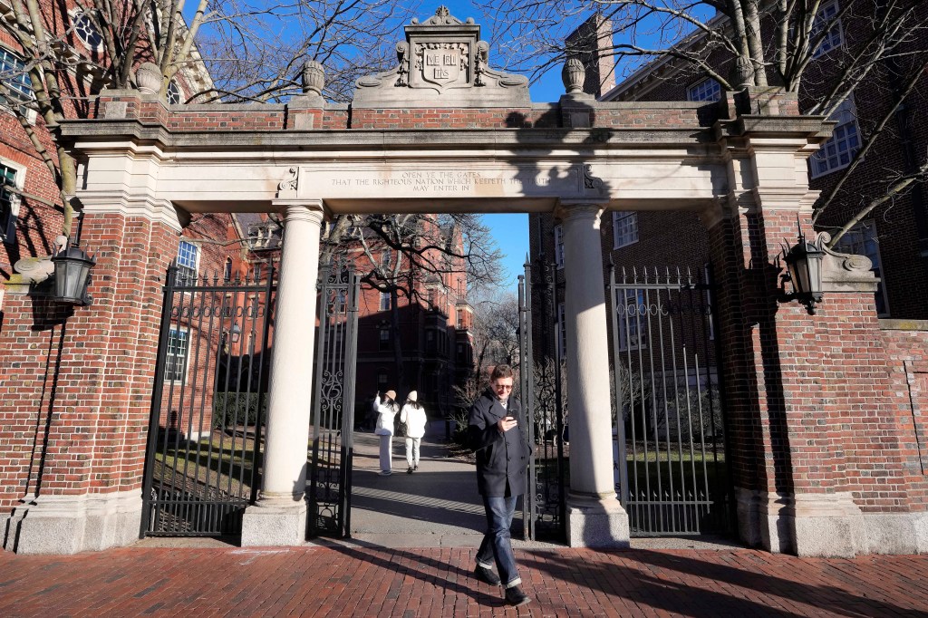 Person walking through Harvard University gate.