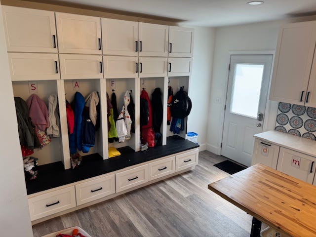 Cabinets labeled with initials with hanging coats.