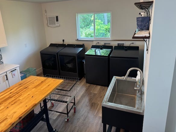 A window above two washers and two dryers in a laundry room.
