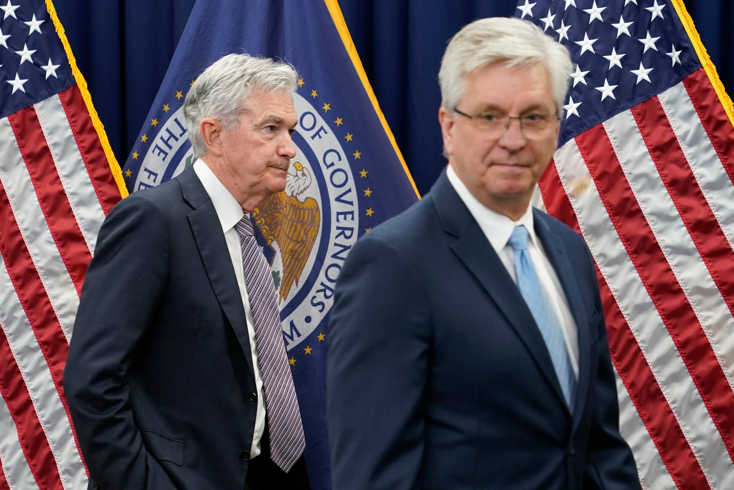 Jerome Powell walks by Christopher Waller after departing a swearing-in ceremony