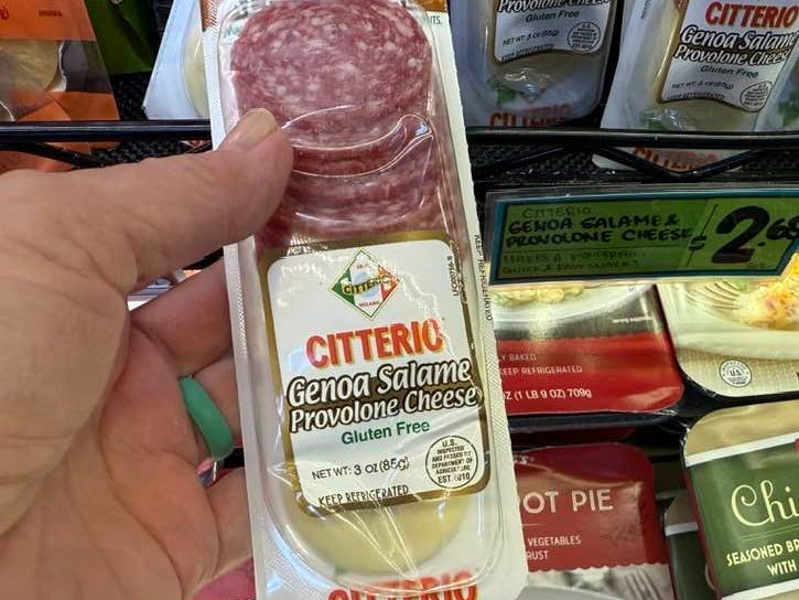 A hand holding a Citterio salami and provolone cheese snack in Trader Joe's.