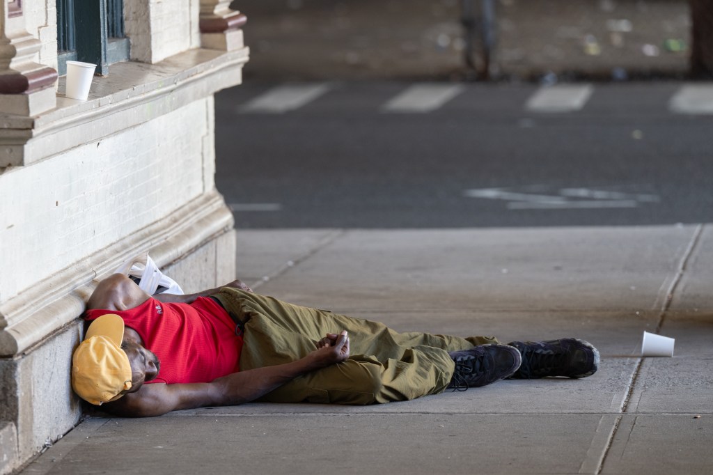 Man sleeping on the sidewalk.