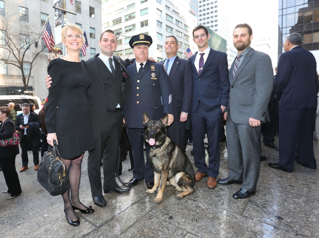 The Byrne family, a police officer, and a police dog at a memorial mass.