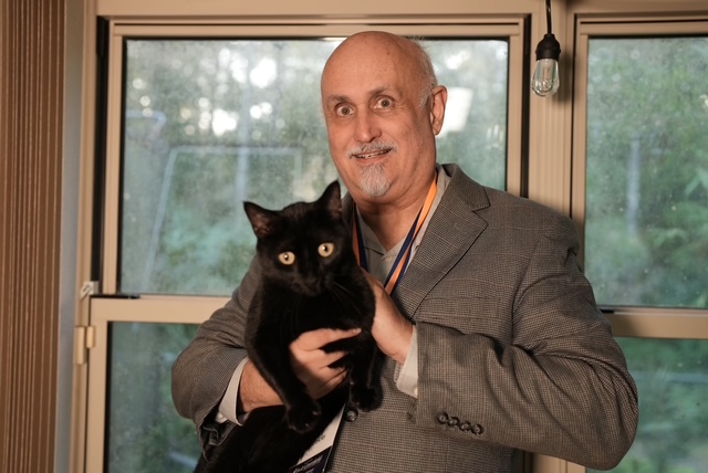 Dr. John Lednicky holding Pepper, his black cat. 