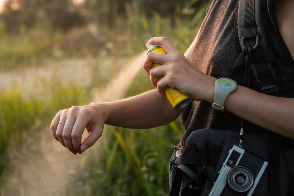 Woman applying insect repellent.