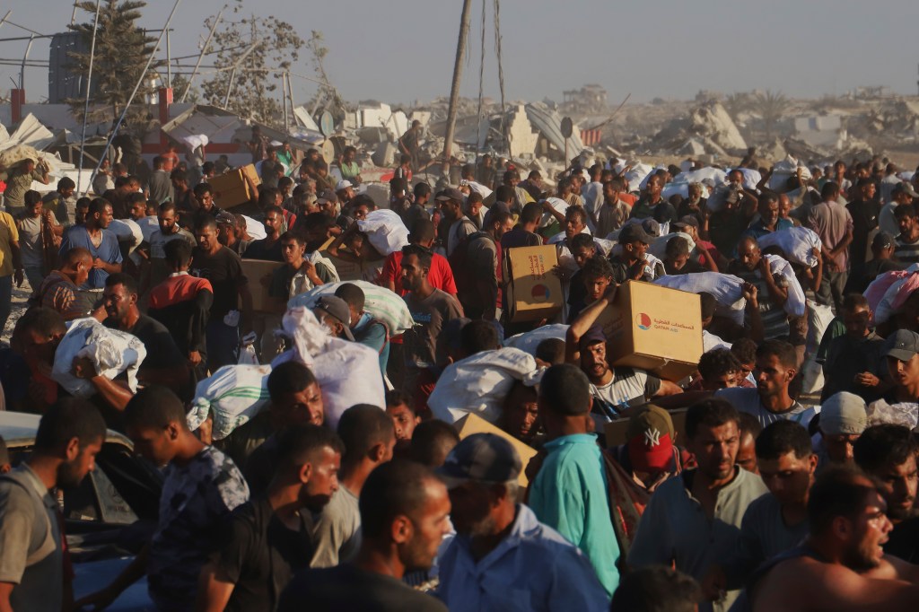 Palestinians carrying humanitarian aid in Gaza.