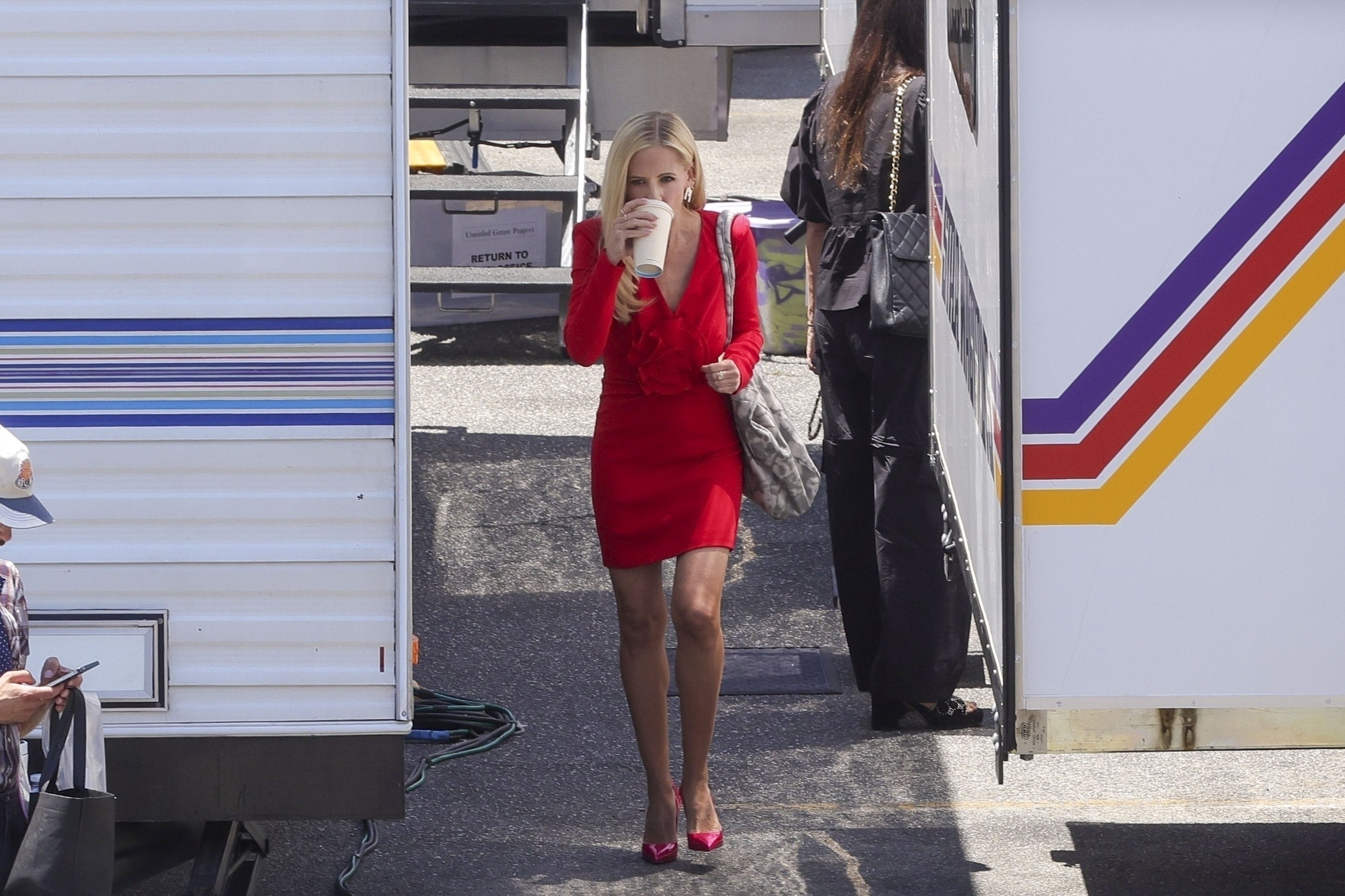 Sarah Michelle Gellar walks among trailers. 