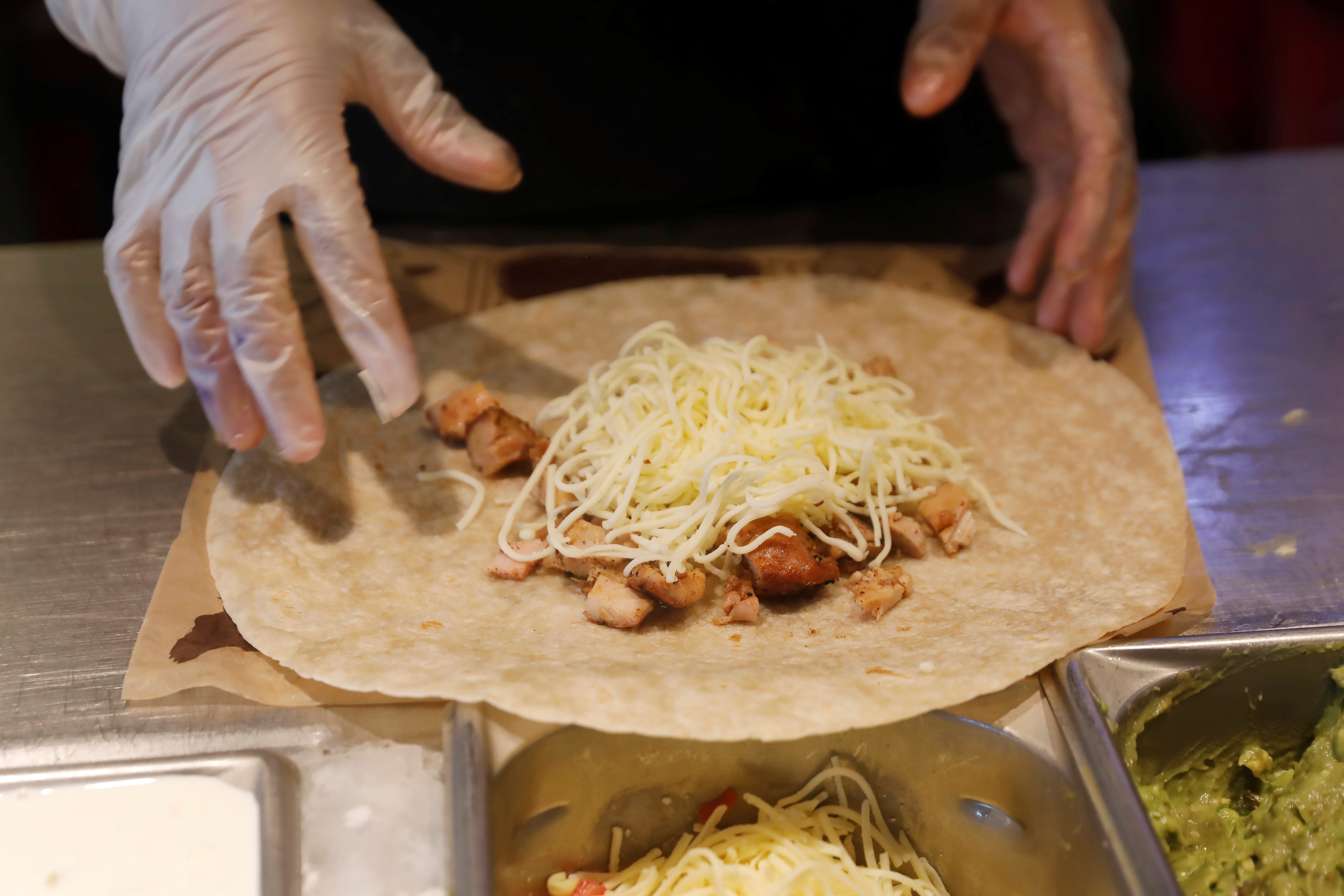 A Chipotle worker makes a quesadilla.