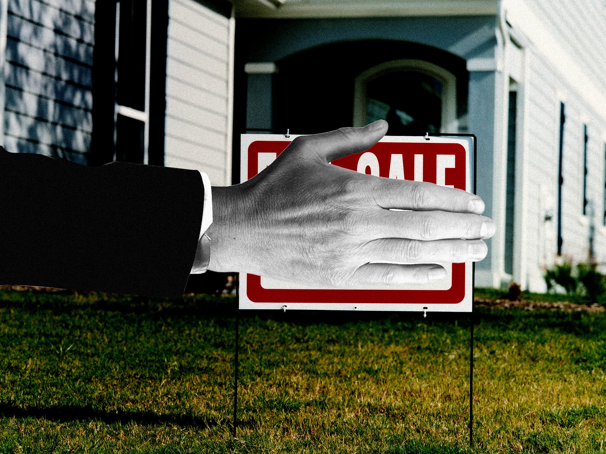 A hand covering a for sale sign.
