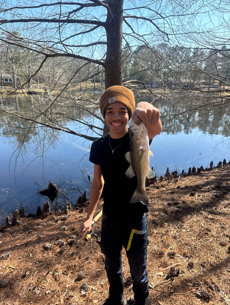 Giovanni Pelletier, an 18-year-old, holding a fish he caught.