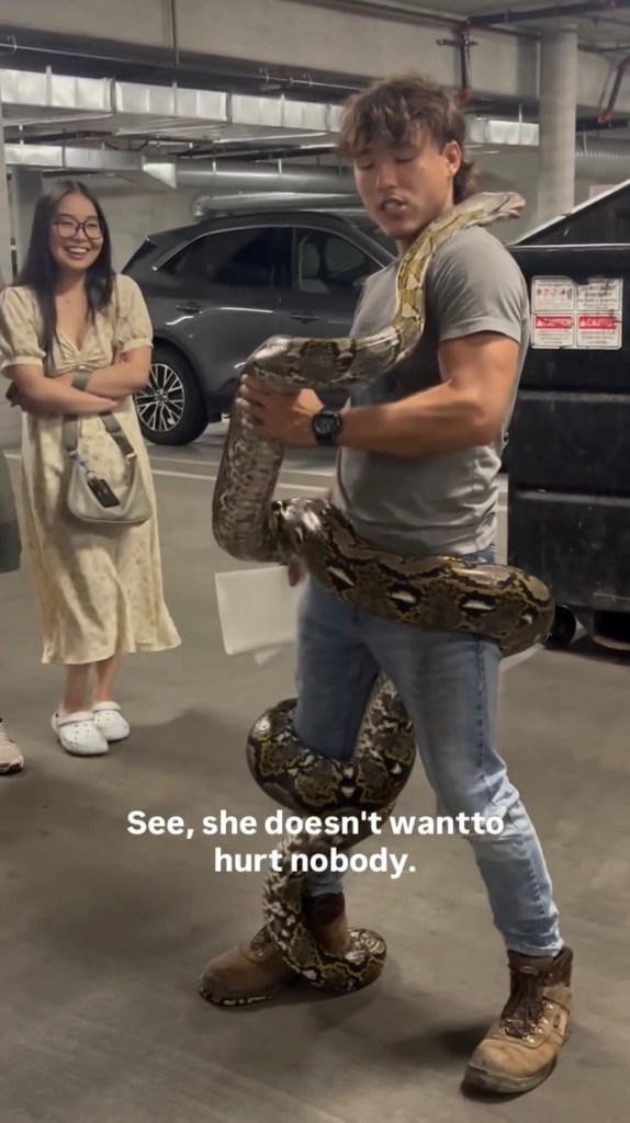A man holding a large python.