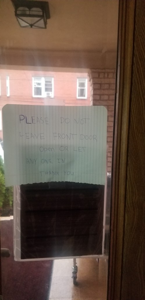 Handwritten note on a door asking people not to leave the front door open or let anyone in.