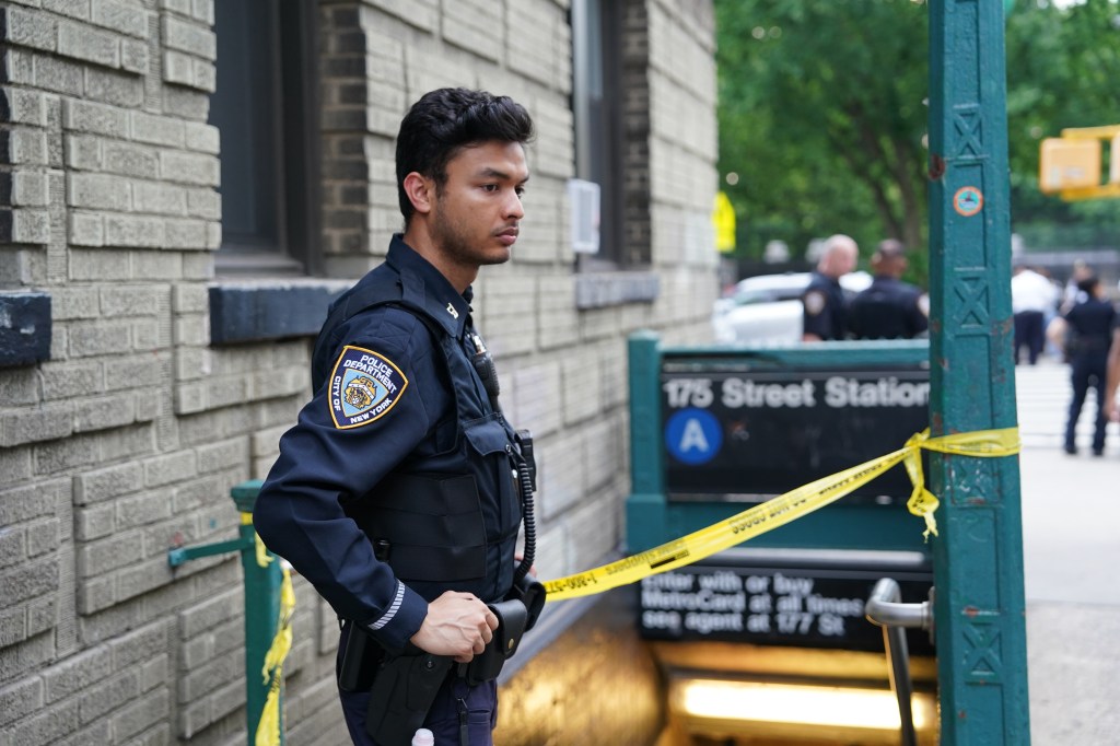 NYPD officer at a subway station crime scene.
