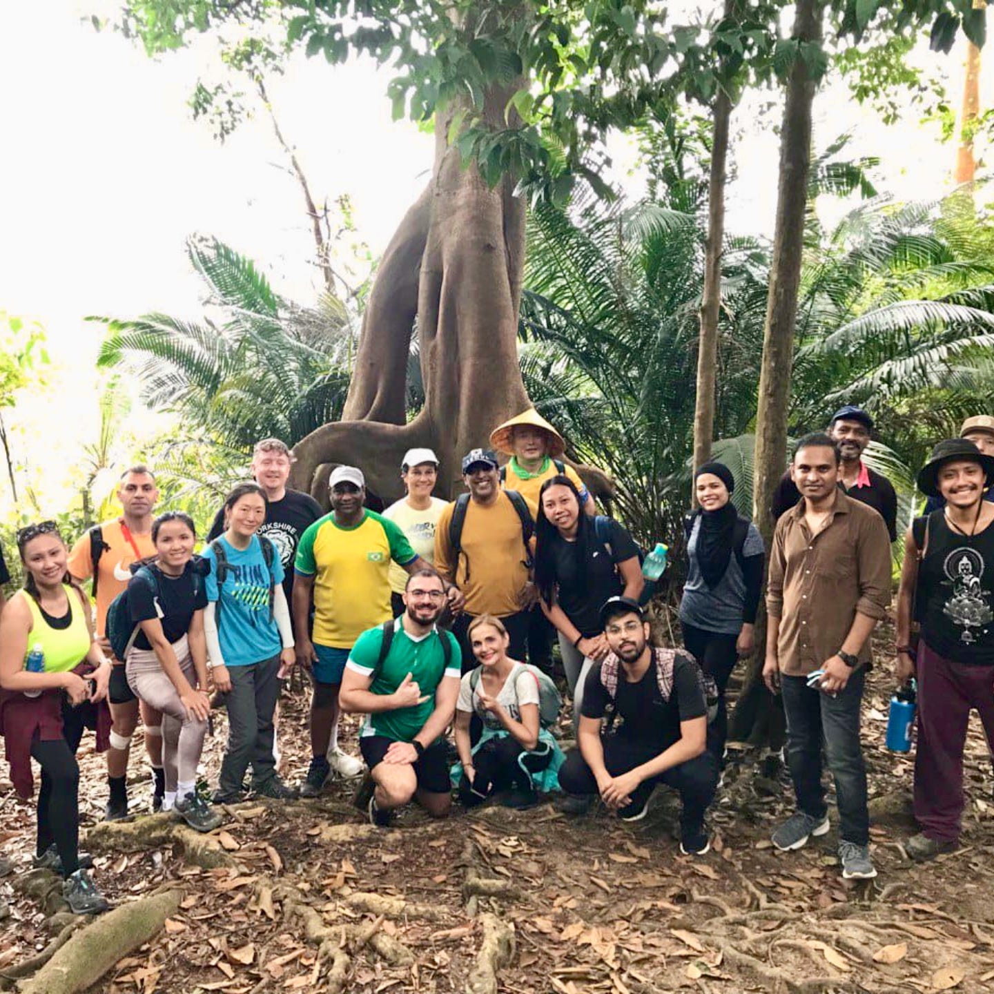 A group of people posing in the middle of jungle during a hike.