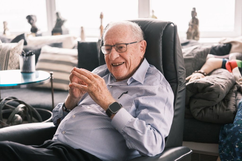 Alan Dershowitz sitting in a chair.