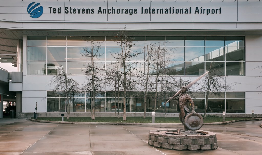 Ted Stevens Anchorage International Airport exterior with statue.