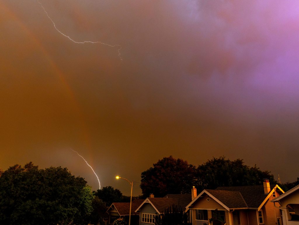 A rainbow is seen as lightning strikes during an early morning storm brought high winds to the area early in Omaha, Neb. on Saturday, Aug. 9, 2025.