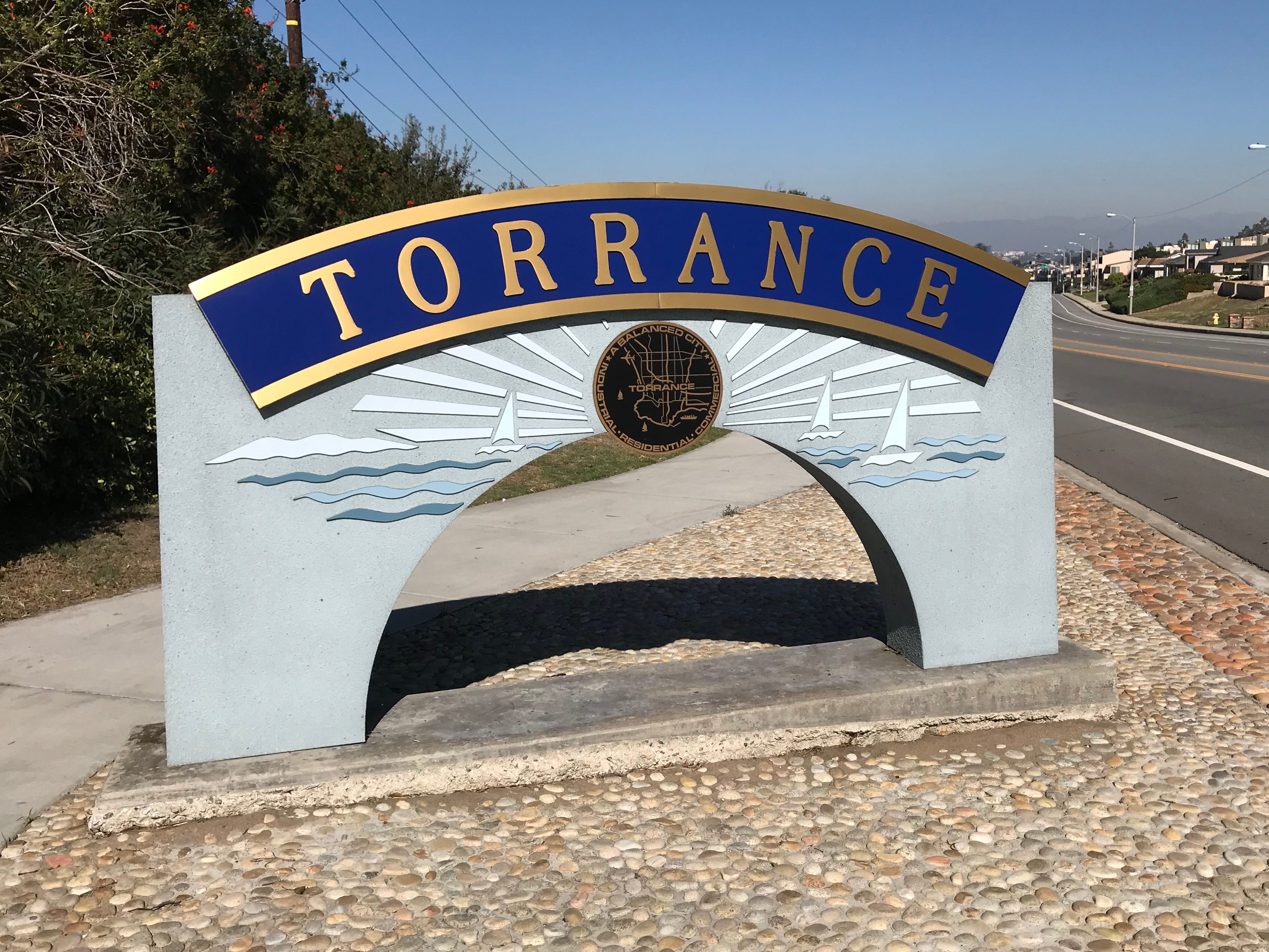 A sign on the side of the road that reads "Torrance."