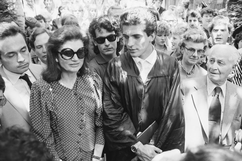 John F. Kennedy Jr. looks at his mother Jacqueline Kennedy Onassis as they stand at his graduation ceremony at Brown University.