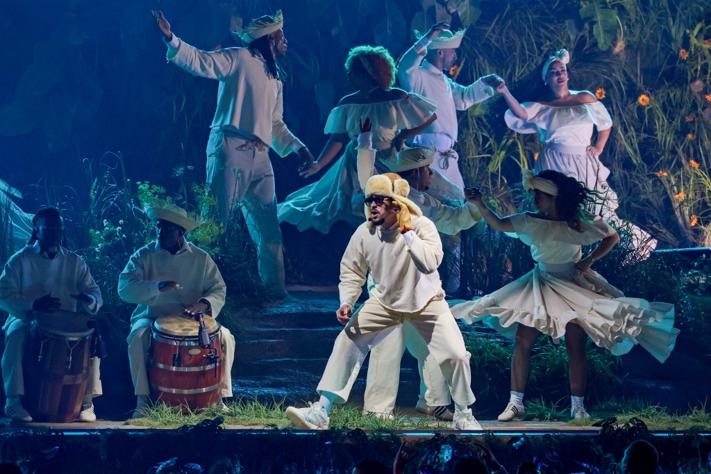 Bad Bunny performing onstage with dancers and musicians.