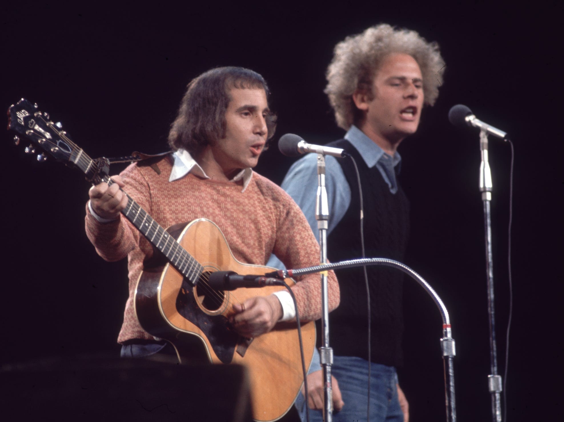 June 1972: American singers and musicians Paul Simon and Art Garfunkel performing at 'Together with McGovern,' a fundraising concert for the presidential candidate George McGovern, Madison Square Garden, New York City. Both sing while Simon plays guitar.