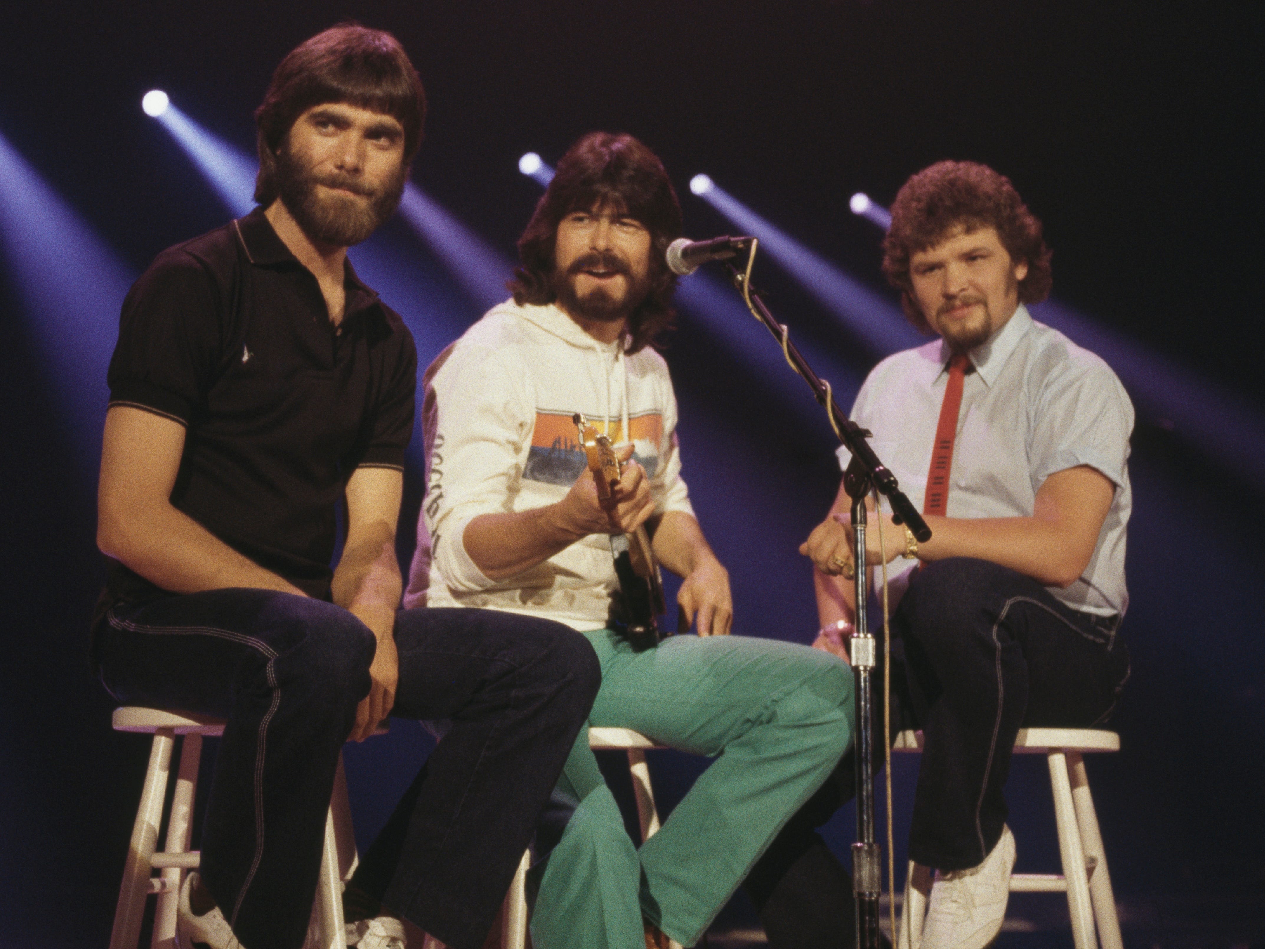Alabama (Randy Owen, Teddy Gentry and Jeff Cook), U.S. country music band, pose sitting on stools, circa 1980..