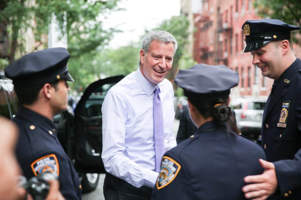 Mayor Bill de Blasio speaking with NYPD officers at a press conference.