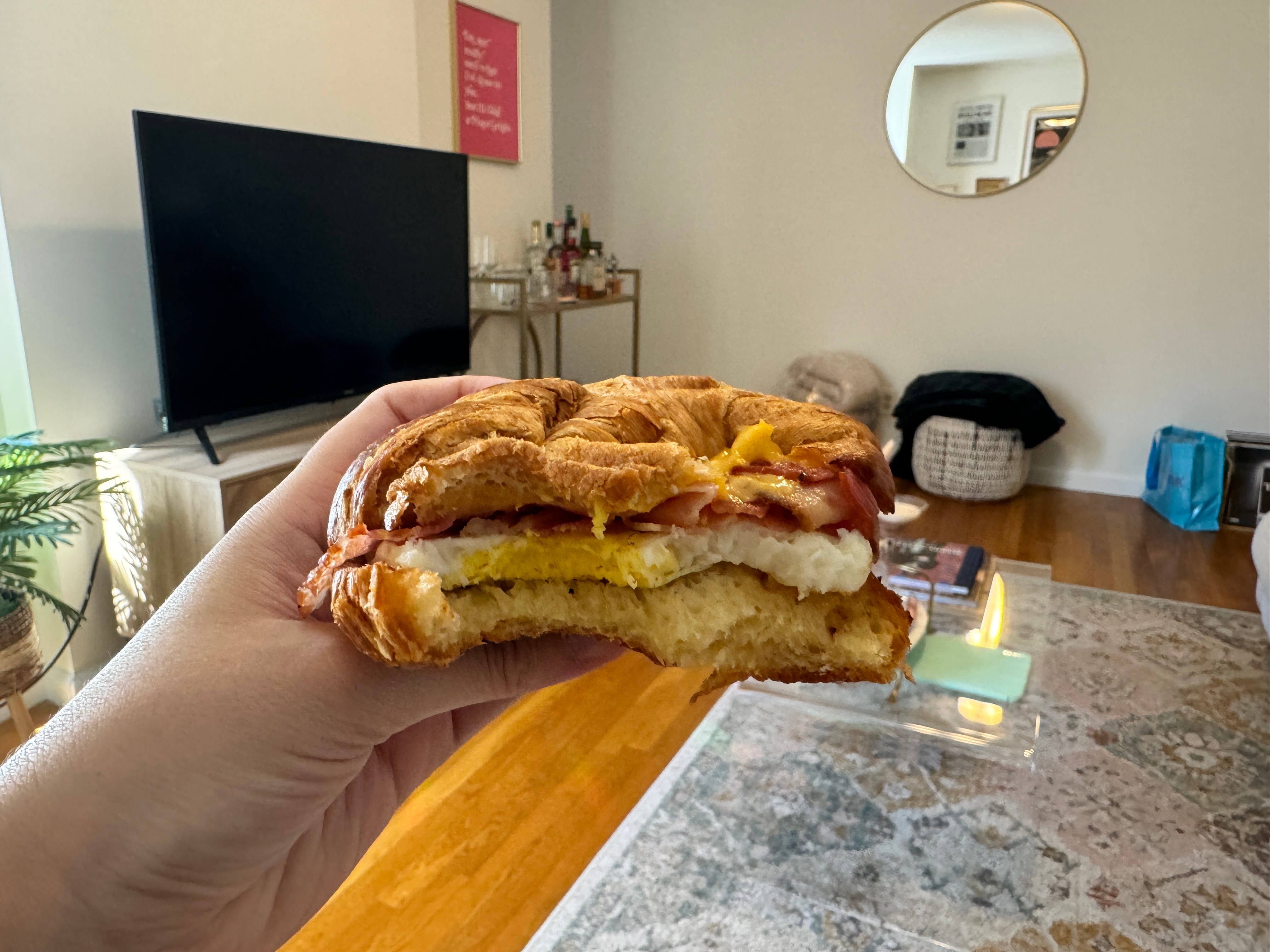 bacon egg cheese sandwich from dunkin with a bite taken out of it
