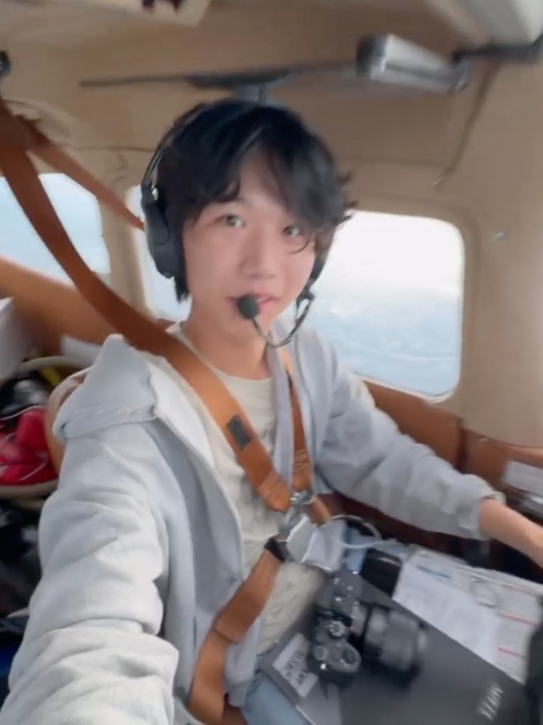 Teenage pilot Ethan Guo in a small plane cockpit.